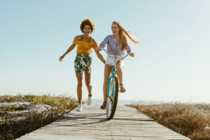 ladies riding bike by beach